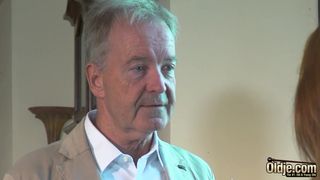 Lusty crimson haired stunner is throating an older fellow's hard-on to pay some of the family's debts